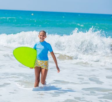 Teenage girl in blue has fun surfing