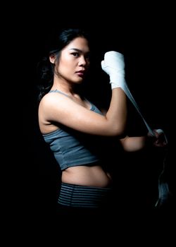 Asian female boxer on black background