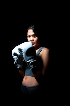 Asian female boxer on black background