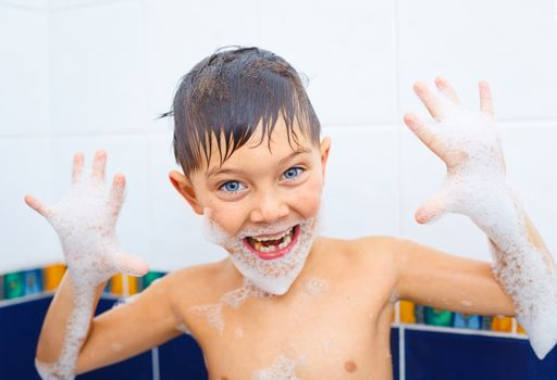 Portrait of cute little boy in bathroom with foam