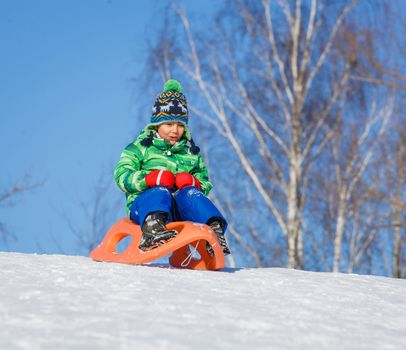 Winter, play, fun - Cute little boy having fun with sled in winter park