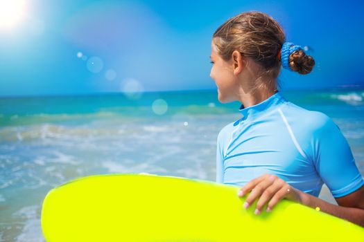 Teenage girl in blue has fun surfing