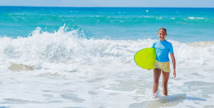 Teenage girl in blue has fun surfing