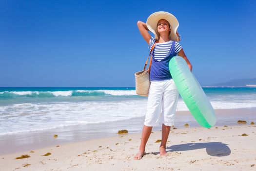 Summer vacation, lovely girl walking on the beach near water