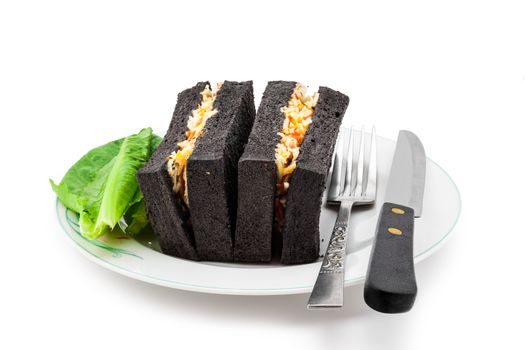 Black bread sanwiches on white plate