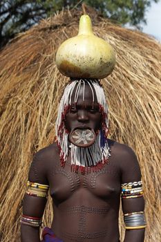 JINKA, ETHIOPIA - NOVEMBER 21, 2014: Mursi woman with traditional lip plate and tattoos on November 21, 2014 in Jinka, Ethiopia.