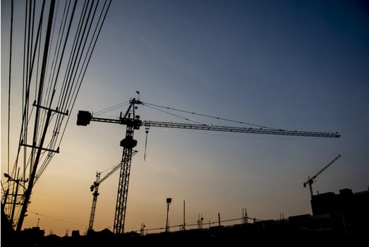 Silhouette of construction crane with sunset sky