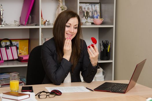 Cute business woman in the office at the computer