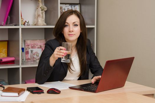 Cute business woman in the office at the computer