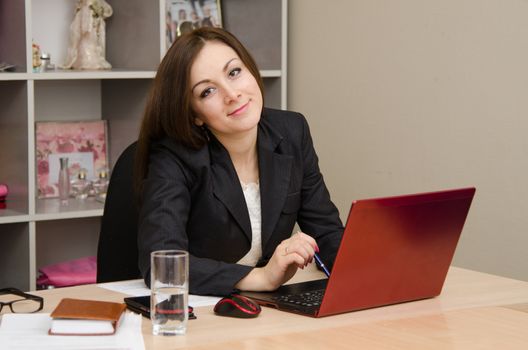 Cute business woman in the office at the computer