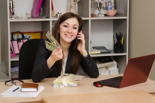 Cute business woman in the office at the computer