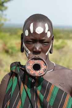 JINKA, ETHIOPIA - NOVEMBER 21, 2014: Mursi woman with traditional lip plate on November 21, 2014 in Jinka, Ethiopia.