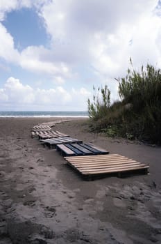 wooden path crossing the sandy  beach