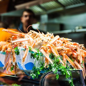 Interior of a busy fish market with detail on fresh scampi