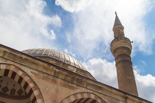 Mosque with minaret on cloudy sky background.