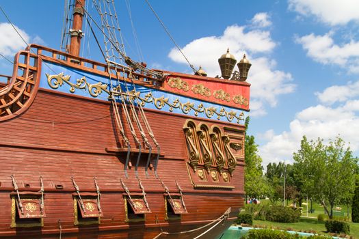 Back side of pirate ship in park on cloudy background.