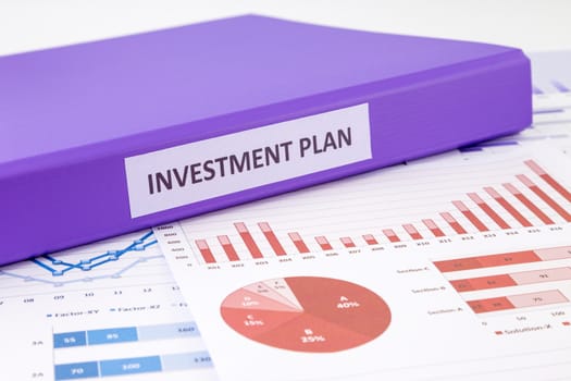 Purple binder of investment plan place on graphs analysis of financial reports, concept to financial management