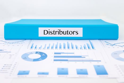 Blue document binder with Distributors word place on graphs analysis and marketing reports