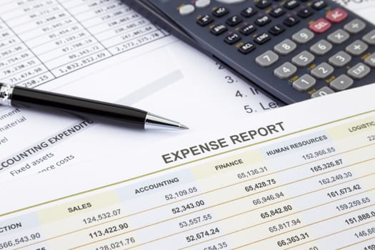 Business expense report with pen and calculator