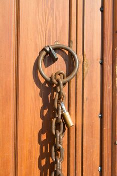 Closed wooden door with chain and lock on.