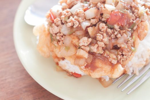 Fried pork with tomato sauce topping on fried egg, stock photo