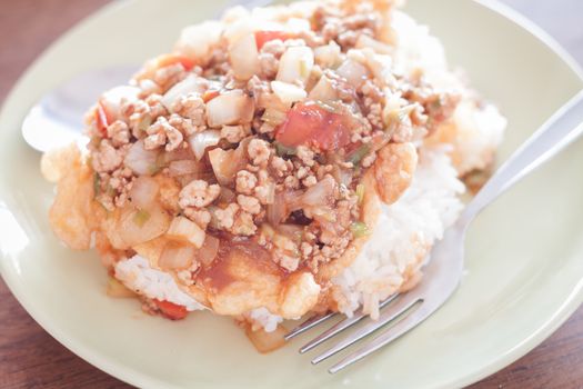 Fried pork with tomato sauce topping on fried egg, stock photo