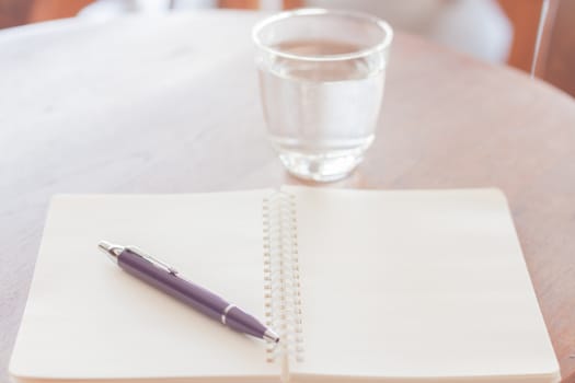 Pen and blank spiral notebook on wooden table, stock photo