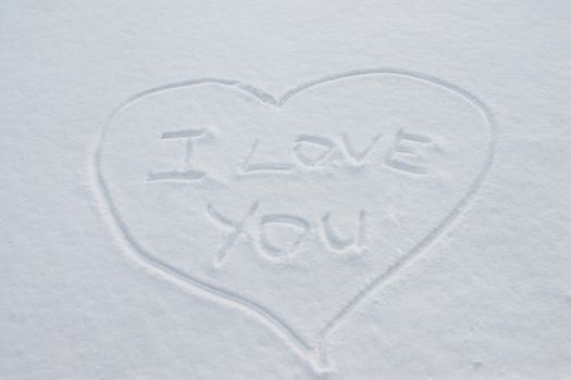 The inscription on the snow, "I love you" inside the heart