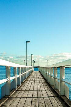 Long pier towards the ocean on bright sunny day