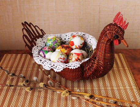 Decorative wicker vase in the form of chicken with Easter eggs inside