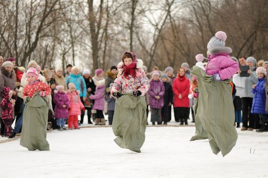 Little girls sack-racing during winter Maslenitsa 2015, carnival in Russia