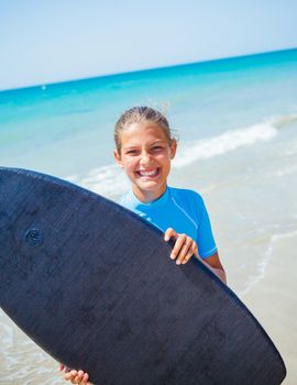 Teenage girl in blue has fun surfing