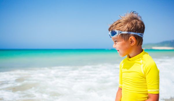 Little cute boy relaxing at the beach near ocean