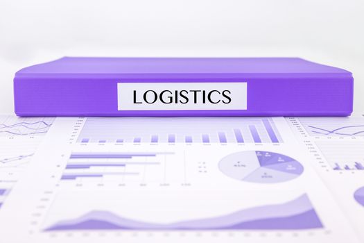 Purple document binder with LOGISTICS word place on graph analysis of distribution reports