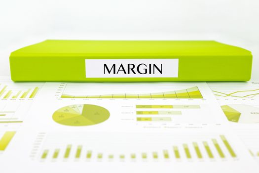 Green document binder with MARGIN word place on graphs analysis and financial reports