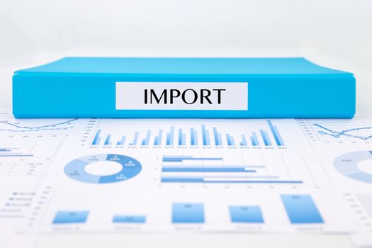 Blue document binder with IMPORT word place on graph analysis of supplier purchase summary reports