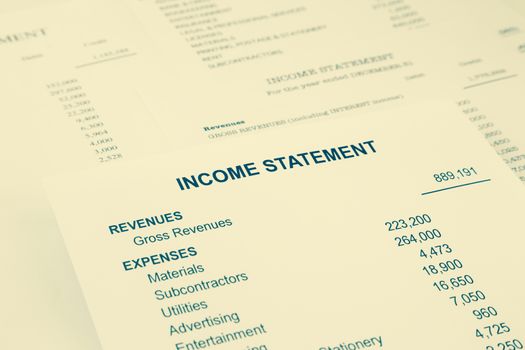 Income statement reports with detail list of revenues and expenses for business accounting concept, sepia tone image