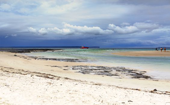 Moona Moona Creek flowing out to the ocean at Huskisson as storm clouds roll in from the east.