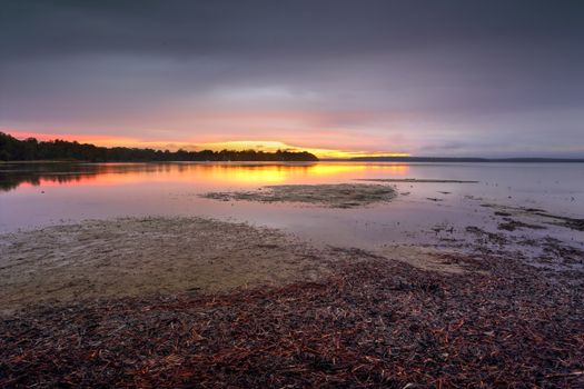 Clouds closed in the skies in the late afternoon.  Standing in rain with my dog to capture the only colour to the south west and a blush of colour on the clouds and reflections in the pristine waters of St Georges Basin Sanctuary Point.
