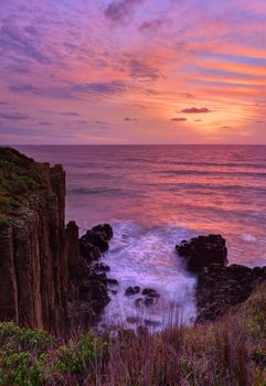 Beautiful sunrise over the ocean with volcanic sea cliffs rising up