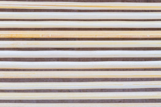 Close up macro of beige brown bamboo mat as striped background texture pattern. Oriental.