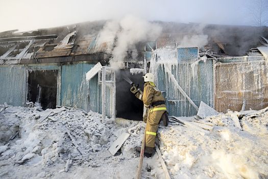 Fire at work holding a fire hose.