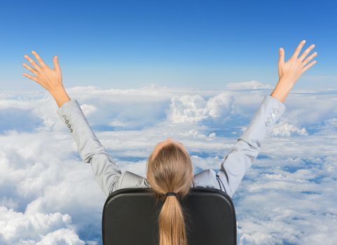 Businesswoman sitting on office chair with her hands outstretched. Sky with clouds as backdrop