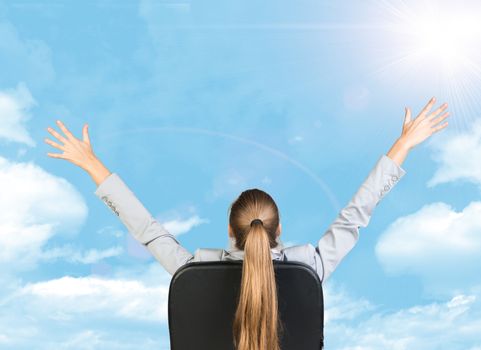 Businesswoman sitting on office chair with her hands outstretched. Sky with clouds as backdrop