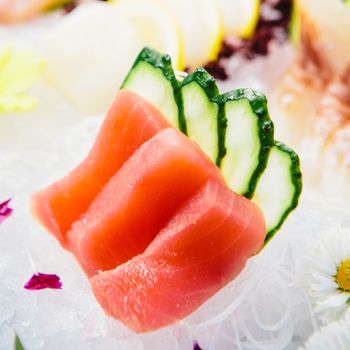 Tuna Sashimi - Maguro fresh raw tuna on Daikon White Radish. Garnished with Ginger, Wasabi, Seaweed, Cucumber, Salad Leaf and Lemon