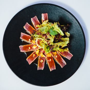 Seared tuna steak called Sashimi traditional Japanese dish with wasabi sauce on side