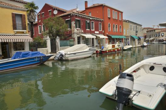 Some people walking along a small canal in Murano, an island in the Venetian Lagoon, northern Italy.