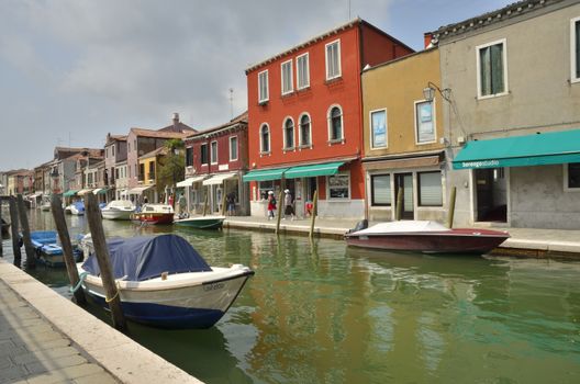 Some people walking along a small canal in Murano, an island in the Venetian Lagoon, northern Italy.
