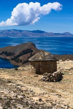 Small stone hut with thatched roof on Isla del Sol (Island of the Sun) in Lake Titicaca, Bolivia. The island is a popular tourist destination. 