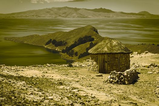 Small round stone hut with thatched roof on Isla del Sol (Island of the Sun) in Lake Titicaca, Bolivia. The island is a popular tourist destination. (Digitally Altered: Split Toned Image)